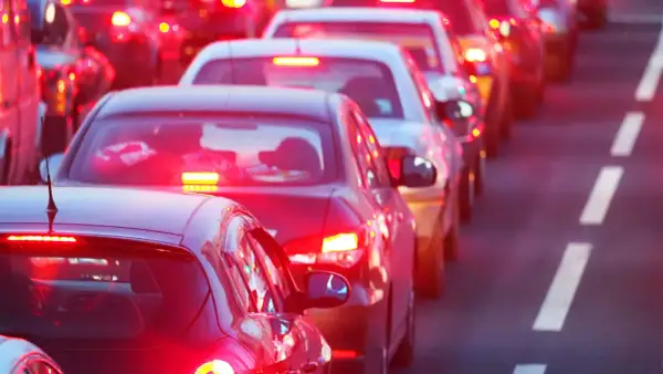 Voitures à l'arrêt dans un embouteillage, leurs feux de position seuls illuminent la route.