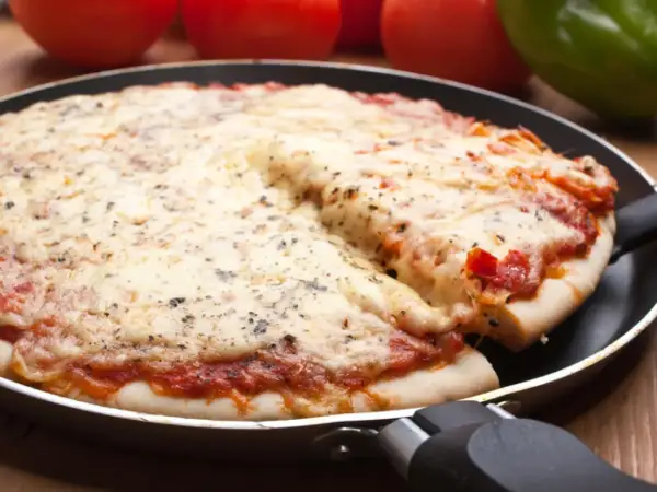 Deliciosa pizza en sartén, con queso derretido y salsa de tomate. Perfecta para compartir.