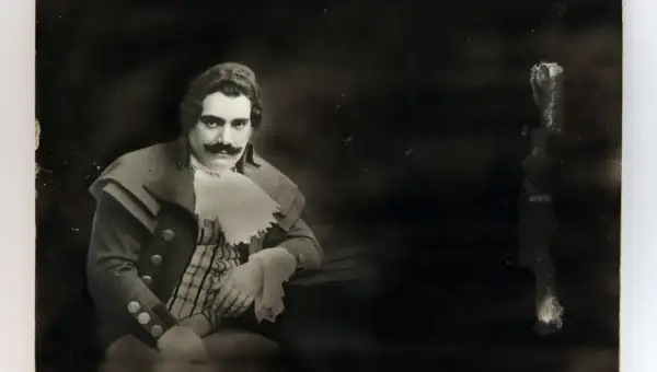 Ritratto di Enrico Caruso, la cui causa morte è ancora oggetto di dibattito. Indossa un costume d'epoca con baffi imponenti.