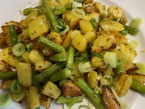 Herzhafte Kartoffel-Bohnen-Pfanne mit Frühlingszwiebeln, goldbraun gebraten und mit Kräutern verfeinert. Ein Genuss!