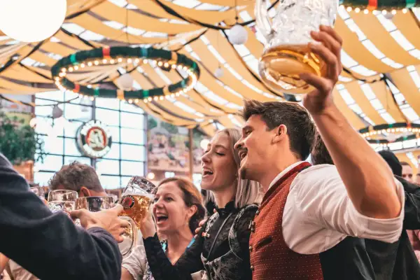 Allegra compagnia brinda con boccali di birra, festeggiando l'Oktoberfest. Litri di birra scorrono in un'atmosfera di gioia.