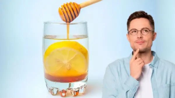 Hombre pensativo junto a un vaso de agua con limón y miel, perfecto para empezar el día.