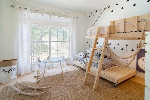 Charming tween girl bedroom ideas: a bunk bed, rocking horse, and playful triangle wall decals create a fun, cozy space.