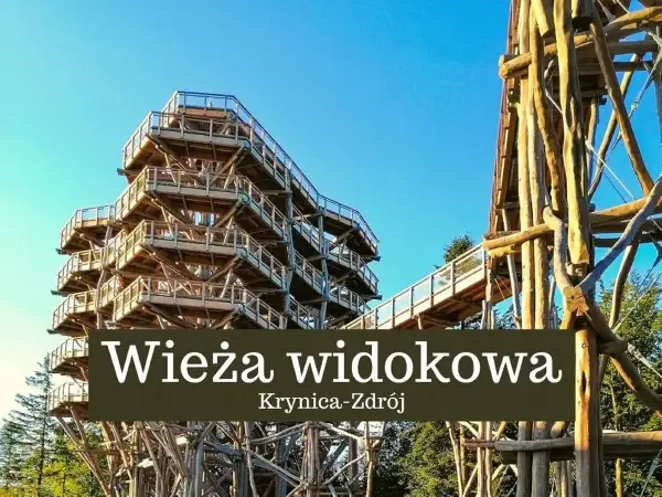 Drewniana wieża widokowa w Krynicy-Zdroju wznosi się ku błękitnemu niebu, oferując wspaniałe widoki na okolicę.
