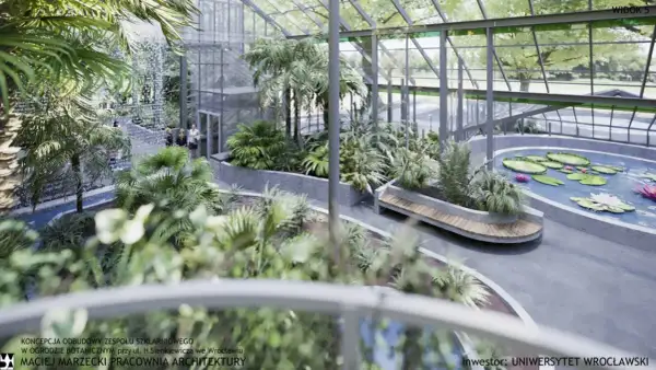 Wrocław, palmiarnia w ogrodzie botanicznym: bujna roślinność, wodospad, staw z liliami wodnymi i ławka.