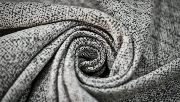 Graues, gemustertes Polyester-Material, kunstvoll zu einer Spirale gedreht.