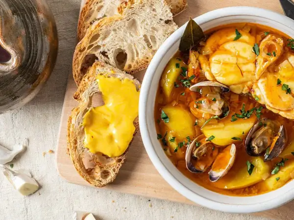 Sopa bullabesa, de origen francés, con mariscos, patatas y pan tostado con alioli.