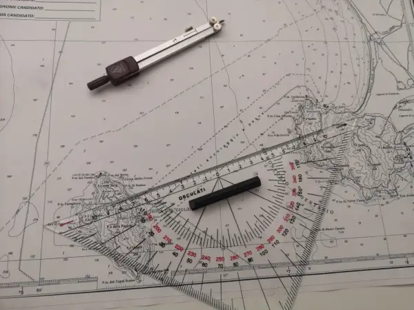 Strumenti nautici su una carta: compasso, righello graduato e goniometro. Un esempio di come leggere latitudine e longitudine.