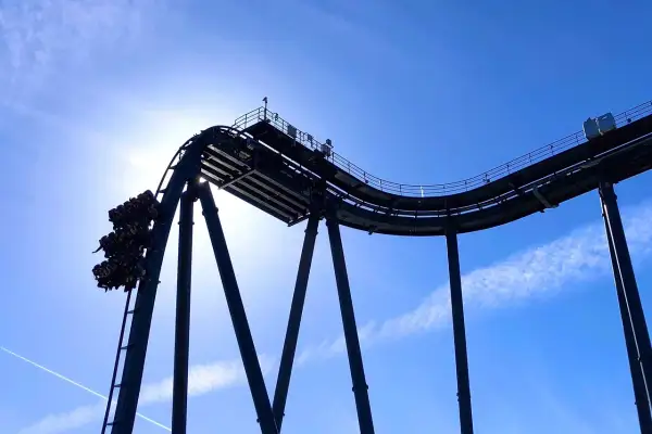 Wagonik z pasażerami na szczycie najwyższego rollercoastera na świecie, tuż przed zjazdem.