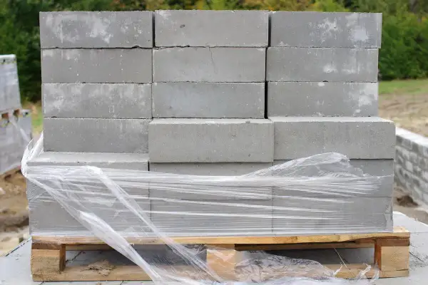 Paleta bloczków fundamentowych owinięta folią. Zastanawiasz się, jak obliczyć ile potrzeba bloczków fundamentowych na budowę?