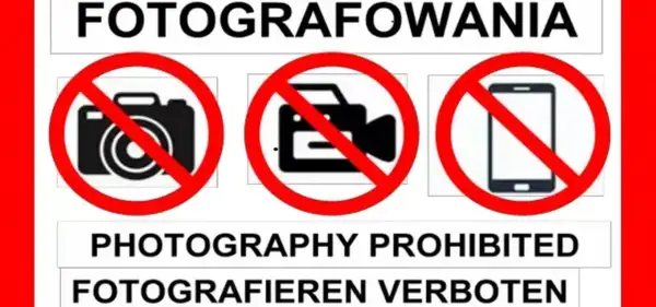 Zakaz fotografowania obiektów wojskowych. Na znaku widać przekreślony aparat, kamerę i telefon.