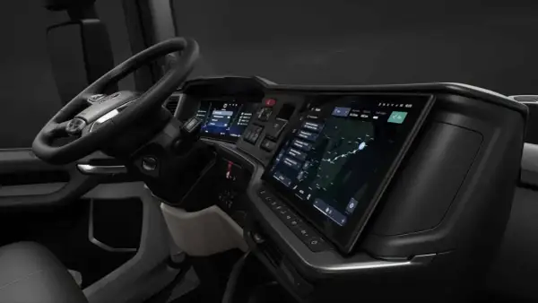 Vue du scania interieur cabine, avec volant, écrans tactiles affichant navigation et informations, et tableau de bord moderne.