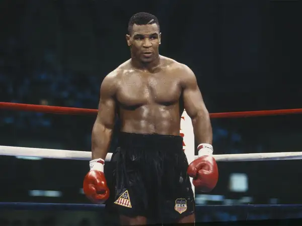 Mike Tyson in the ring, ready to fight. His intense gaze and powerful physique embody the spirit of how to fight like Mike Tyson.