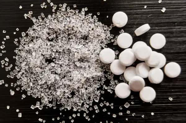 Sorbitol co to? Porównanie kryształków cukru i tabletek słodzika.