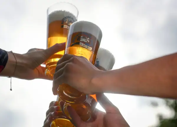 Hände stoßen mit Biergläsern an, ein Moment der Freude bei Bier Events.