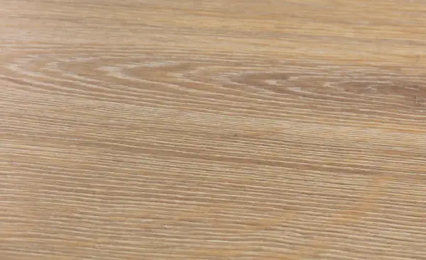Textura de suelo laminado de madera clara, con vetas finas y paralelas. Podría ser un ejemplo de problemas de suelo laminado artens.
