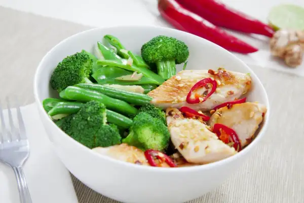 Miseczka z kurczakiem, brokułami i fasolką szparagową, posypana chili. Idealne danie na dieta białkowo tłuszczowa.