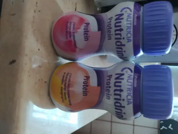 Dwa napoje Nutridrink Protein o różnych smakach, wspierające tycie.