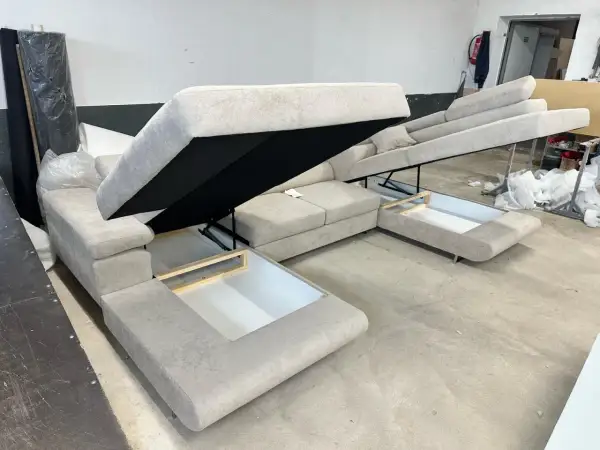 Sofa z systemem rozkładania Delfin, z otwartymi schowkami pod siedziskami.
