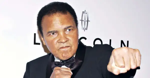 Muhammad Ali, the greatest of all time, in a boxing stance. He wears a tuxedo with a bow tie.