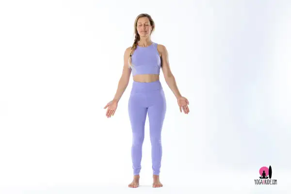 Donna in posizione della montagna yoga, con occhi chiusi e braccia aperte.