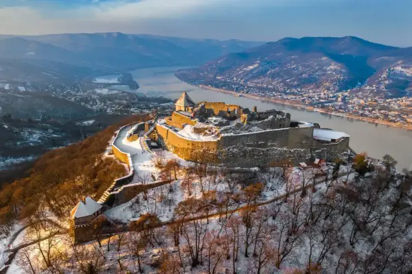 Zimowy krajobraz z górującym nad Dunajem **Wyszehrad**, ośnieżone ruiny zamku i malownicza dolina.