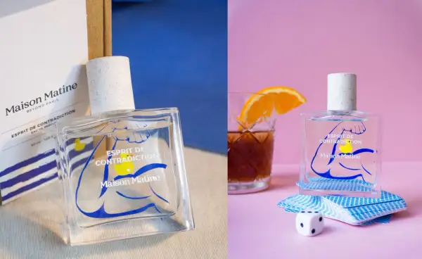 Perfumy Maison Matine Esprit de Contradiction w szklanej butelce z niebieskim wzorem. Obok kostka do gry i talia kart.