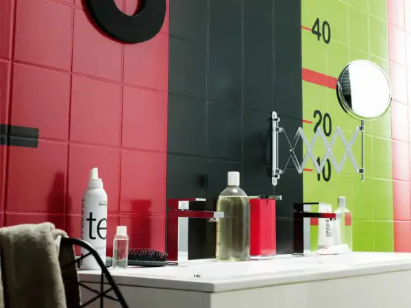 Un mur de salle de bain aux carreaux rouges, noirs et verts, avec des marques de croissance. Une inspiration peinture céramique pour un décor audacieux.