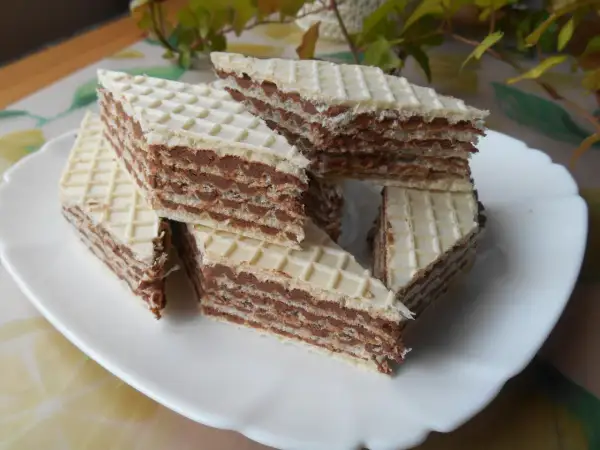 Kawałki wafli z kremem czekoladowym, przypominające smakiem wafle z mlekiem w proszku, ułożone na białym talerzu.