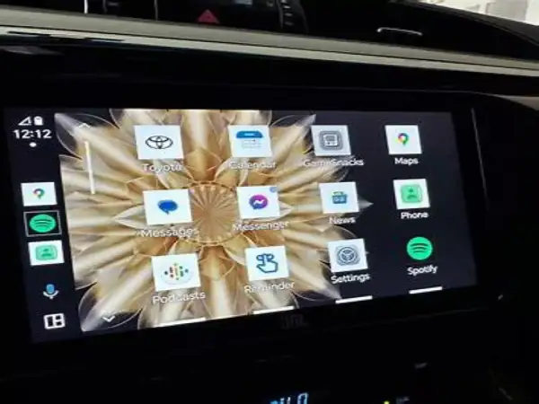 Ekran multimedialny w samochodzie z ikonami aplikacji: Toyota, Calendar, GameSnacks, Maps, Phone, Spotify. Zlink działa płynnie.