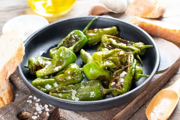 Friggitelli in padella, cotti al punto giusto e cosparsi di sale grosso, pronti per essere gustati con pane fresco.