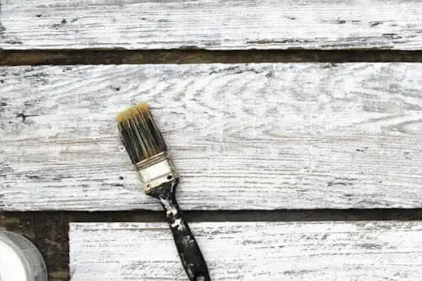 Pennello sporco su assi di legno verniciato con cementite, effetto shabby chic.
