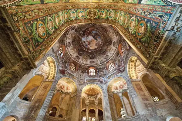 Interno di un edificio con mosaici dorati e affreschi, uno dei siti UNESCO Emilia Romagna.