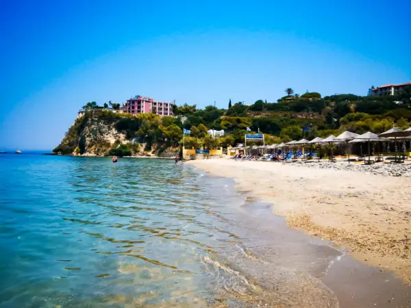 Piękna plaża Alykanas z turkusową wodą, piaszczystym brzegiem i hotelami na klifie. Idealne miejsce na wakacje.