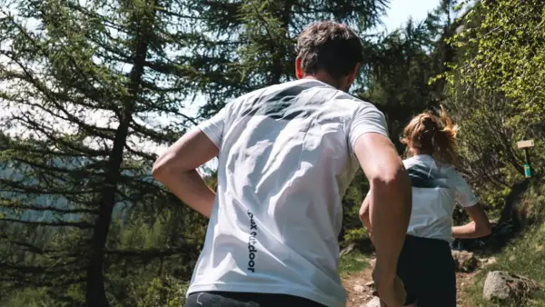 Couple en pleine course en forêt, profitant d'un moment de sport aérobie en pleine nature.