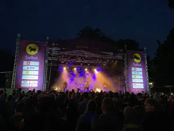Band spielt auf der Hauptbühne beim EselRock Festival. Ein großes Publikum feiert die Musik.