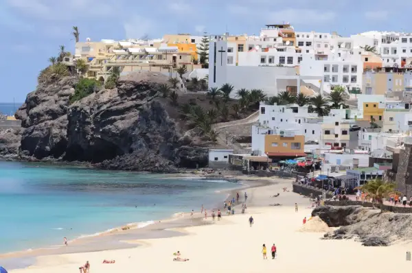 Piękna plaża i białe domy na Fuerteventurze. Idealne miejsce na wakacyjny **fuerteventura plan zwiedzania**.