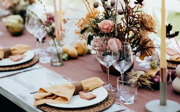 Vacker duka bord inspiration med höstfärger, blommor, ljus och glas. Perfekt för en mysig middag.