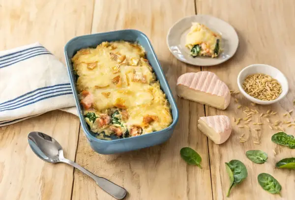 Un plat gratiné de saumon et épinards, parfait pour un repas du soir familial rapide. Accompagné de fromage et de pâtes orzo.