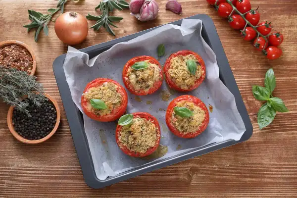 Pomodori gratinati in friggitrice ad aria, ripieni e dorati, pronti per essere gustati.