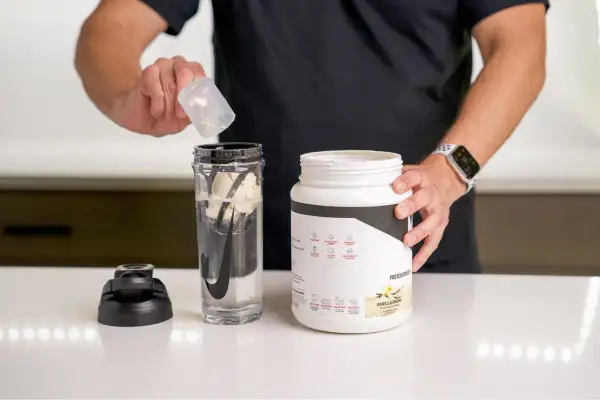 Mann bereitet einen Protein Shake vor. Ob vor oder nach dem Training, dieser Shake ist ideal.