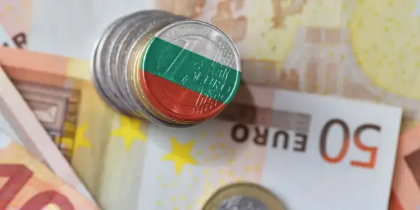 Monety z flagą Bułgarii, symbolizujące lew bułgarski, leżą na banknotach euro.