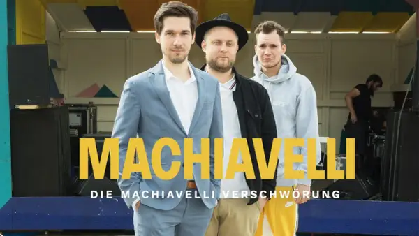 Drei Männer stehen vor einer Bühne, auf der "MACHIAVELLI" steht. Sie sind die Macher des Machiavelli Podcast.