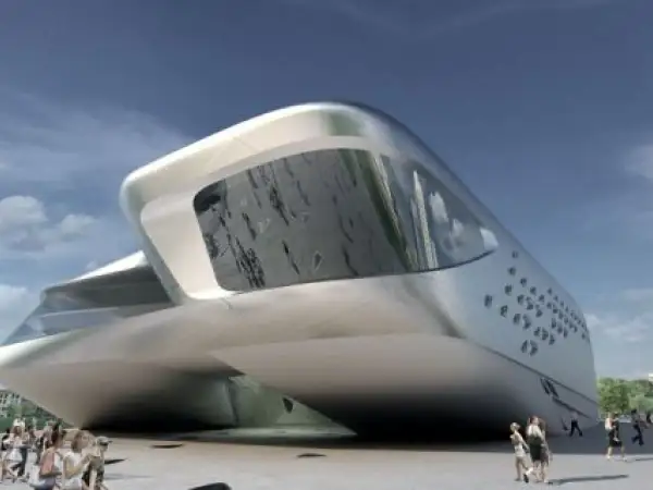 Futurystyczny budynek w kształcie łodzi, dzieło Zaha Hadid, lśni w słońcu. Ludzie spacerują przed jego niezwykłą fasadą.