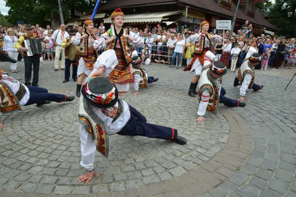Tancerze w barwnych strojach ludowych wykonują akrobacje podczas międzynarodowego festiwalu folkloru ziem górskich.