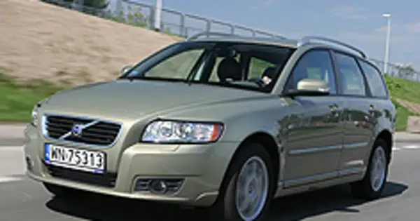 Złoty Volvo V50 2.0D na drodze, z widocznym kierowcą za kierownicą.