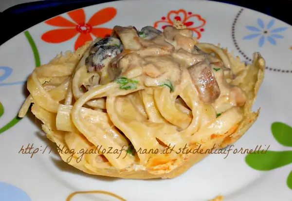 Scialatielli ai funghi cremosi serviti in un cestino croccante, un piatto invitante e saporito.