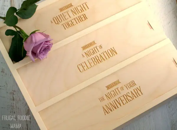 Drewniane pudełko na wino z grawerem "A Quiet Night Together", "A Night of Celebration", "The Night of Your Anniversary" i różową różą.