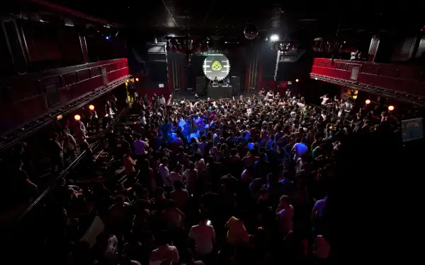 Folla in delirio al Nitsa Club, luci soffuse e musica pulsante.