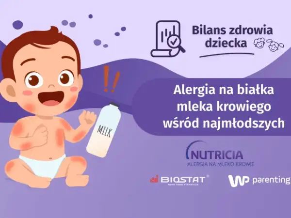 Uśmiechnięte dziecko z zaczerwienioną skórą obok butelki z mlekiem. Temat: po jakim czasie pojawia się alergia na mleko modyfikowane.